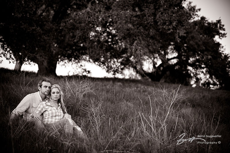 Beautiful couple sitting below oaks, Firestone Vineyard.