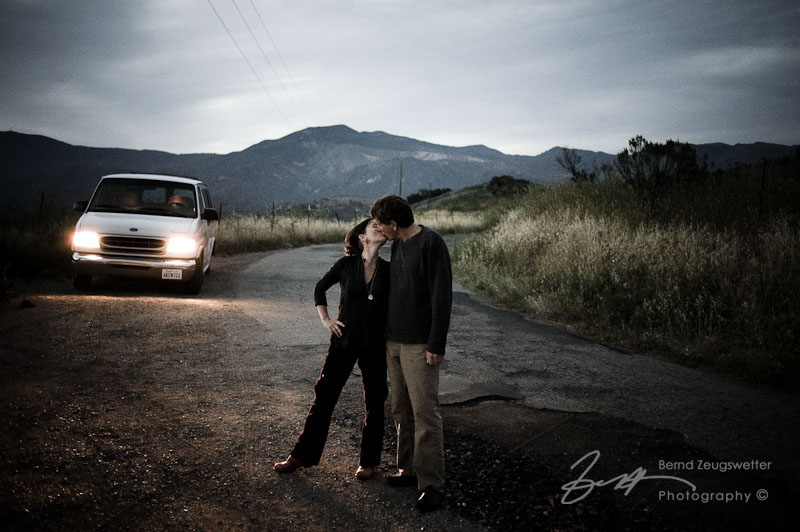 01 couples portraits Couple kissing on country road at dusk, Goleta.