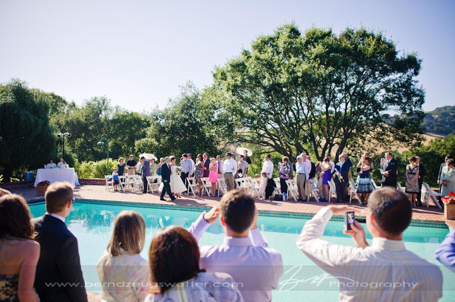 Bride and father walking down the isle next to pool at the Thomas Estate.