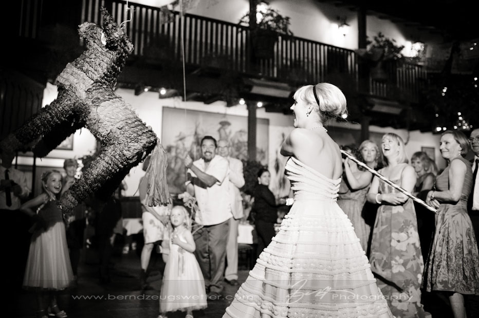 Bride swinging at pinata, El Paseo Restaurant, Santa Barbara wedding photographer.