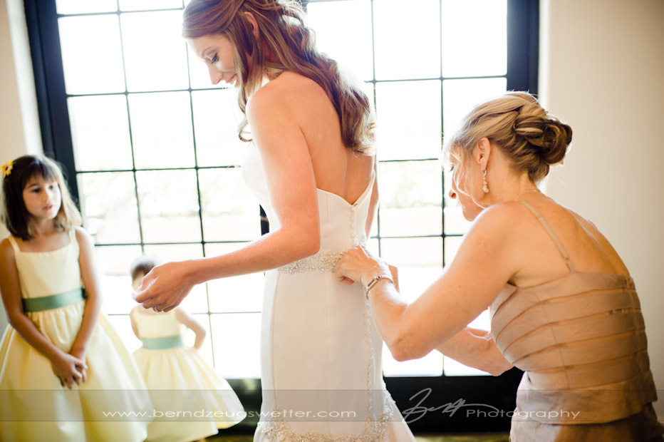 Mother helping bride with wedding dress, Santa Barbara.
