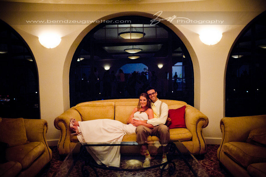 Wedding couple lounging on big sofa at wedding reception, Montecito Wedding Photographer.
