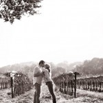 Engagement photo of couple in front of rows of wine.